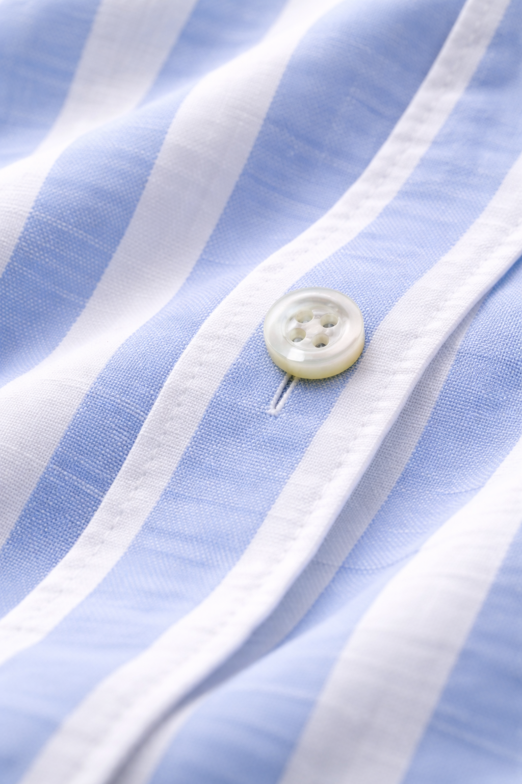 Close-up of a button on a blue and white striped fabric